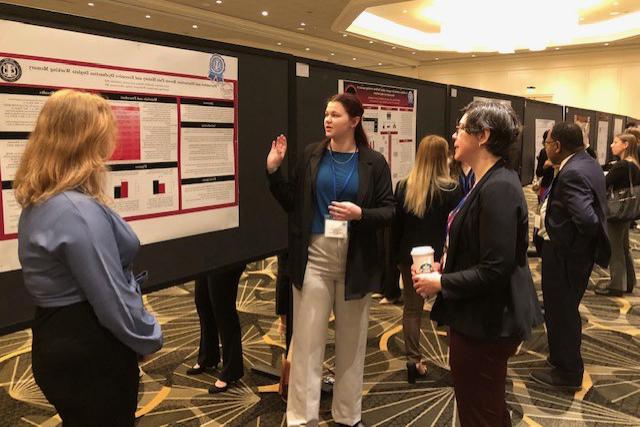 Sylvia Johnson '24 explains her research at a poster session to a conference attendee